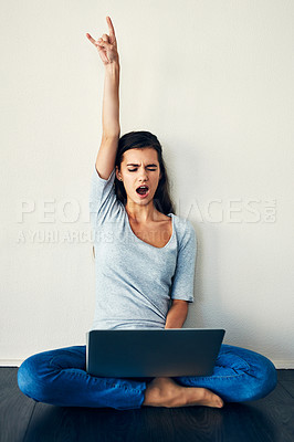 Buy stock photo Shot of a young woman sitting on the floor while using a laptop