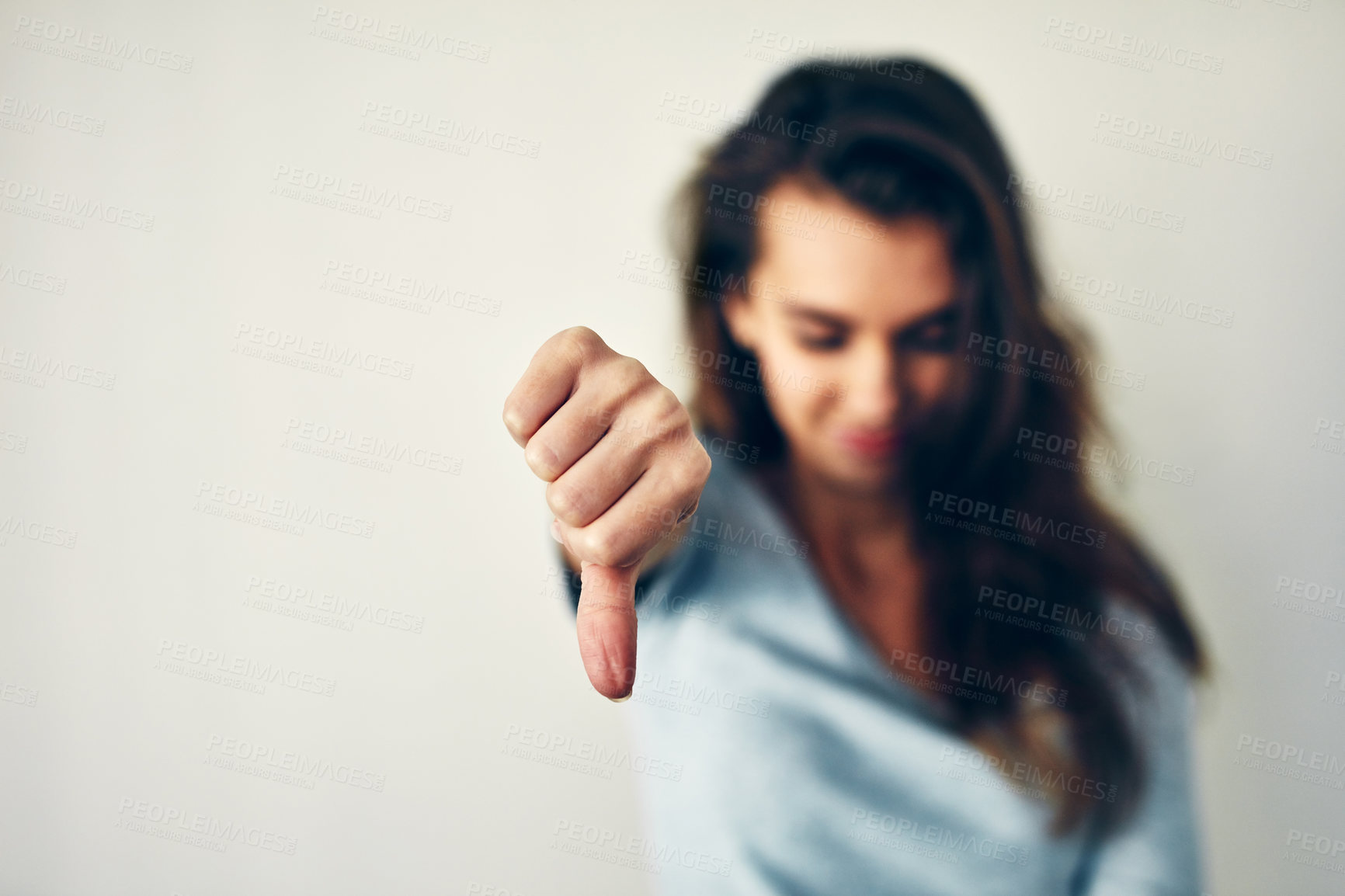 Buy stock photo Woman, person and hand with thumbs down in studio for bad review, disagreement and wrong choice. Mockup space, girl and no emoji for negative feedback, complaint and decline vote on white background