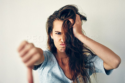Buy stock photo Cropped shot of a young woman showing thumbs down