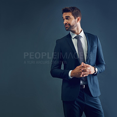 Buy stock photo Studio shot of a handsome young businessman posing against a dark background