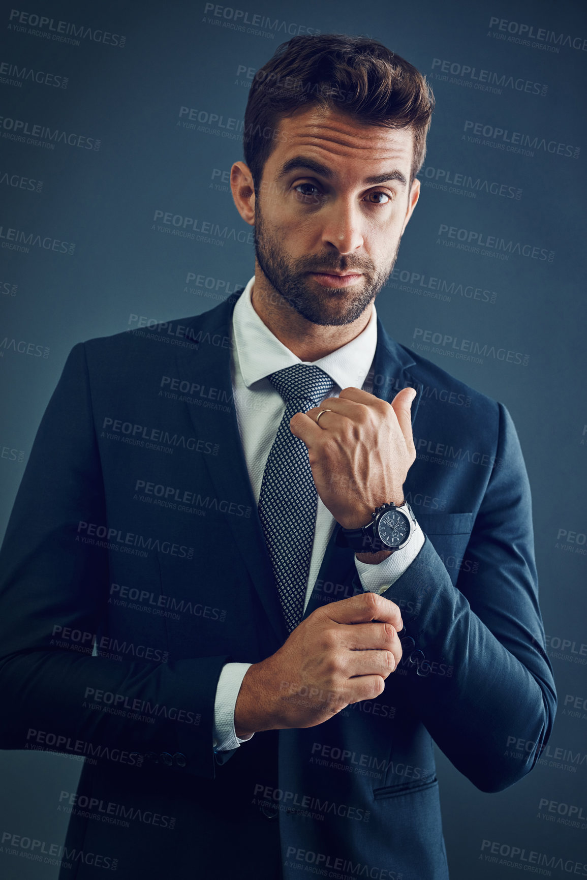 Buy stock photo Studio, business and portrait of man with luxury watch, confidence and designer style for professional secret agent. Corporate fashion, spy or serious businessman with pride, suit and blue background