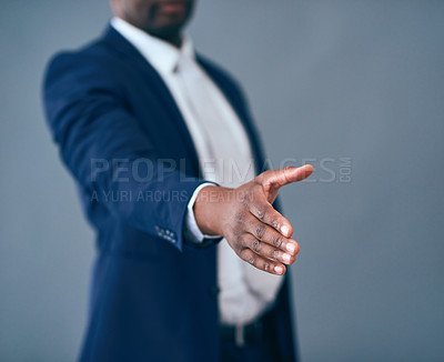 Buy stock photo Studio shot of an unrecognizable corporate businessman putting his hand out for a handshake against a gray background