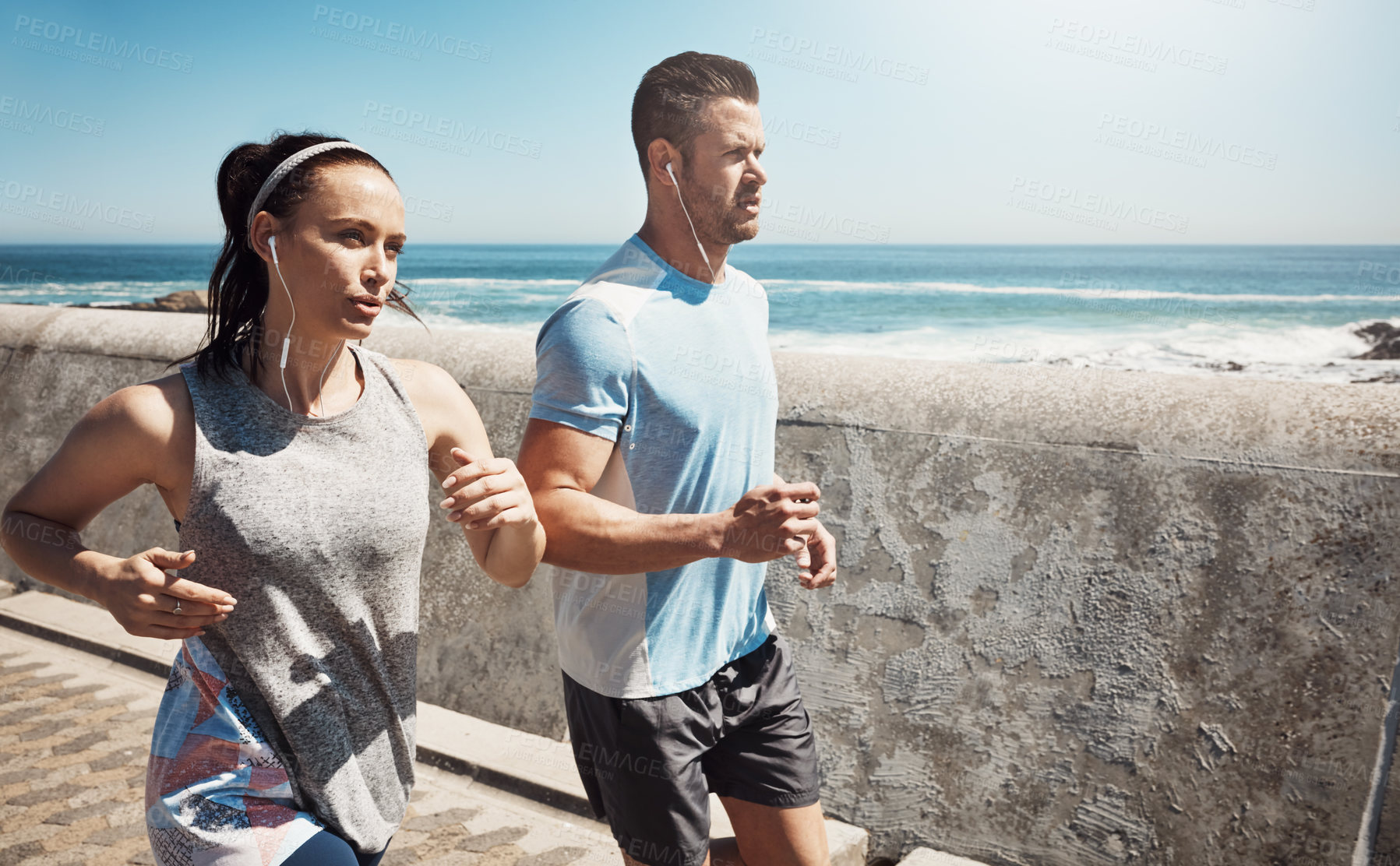 Buy stock photo Running, promenade and couple by sea for fitness listening to music, audio and radio for workout. Health, wellness and man and woman outdoors for exercise, marathon training and cardio by ocean