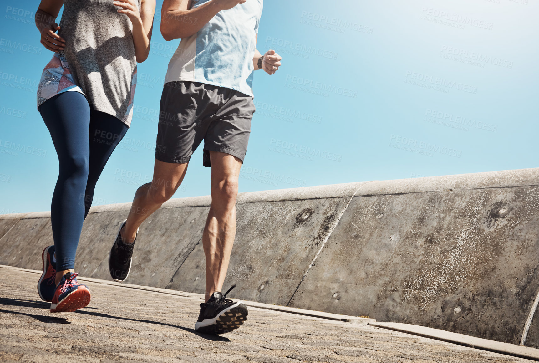 Buy stock photo Cropped shot of a young couple out for a run on the promenade