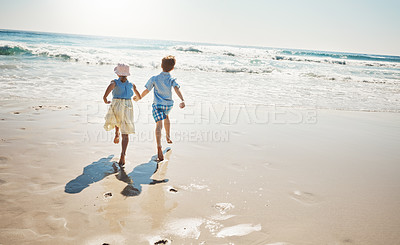Buy stock photo Shot of two adorable young children running hand-in-hand on the beach