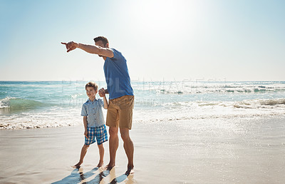Buy stock photo Shot of a father and his little son bonding together at the beach