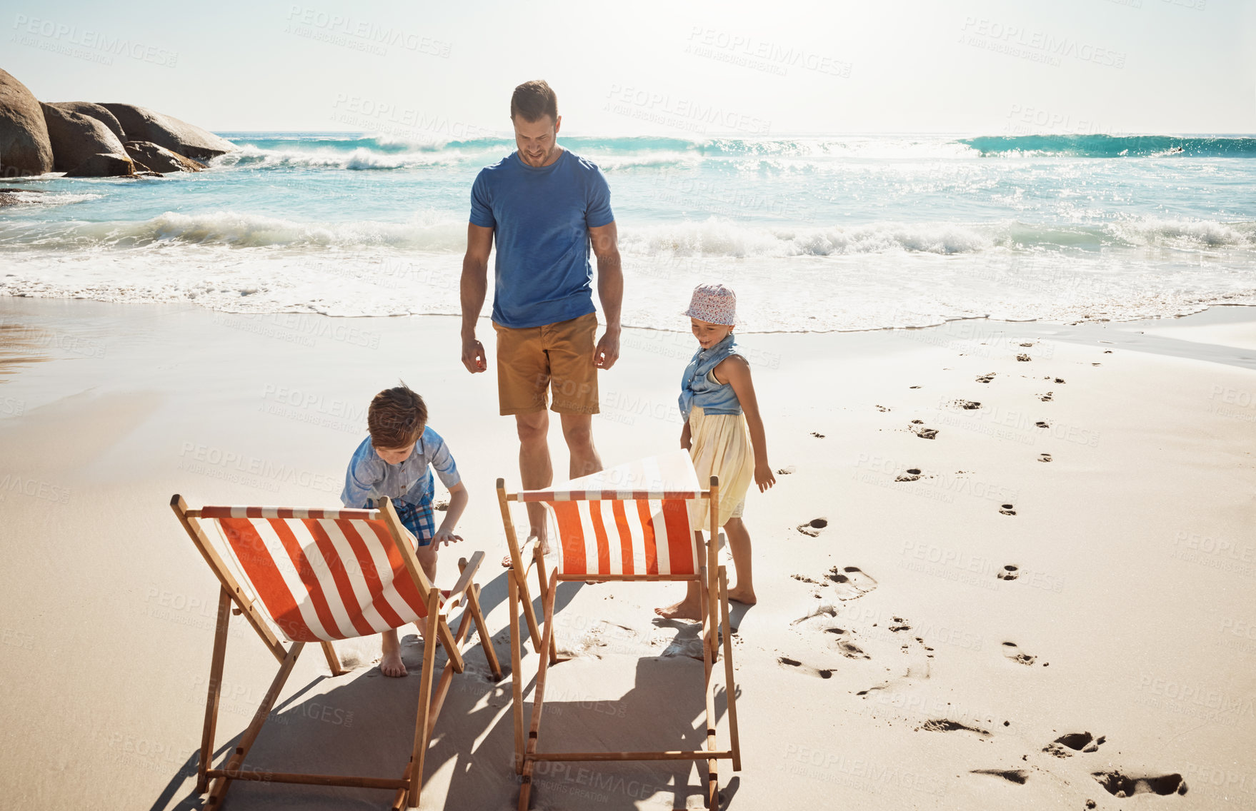 Buy stock photo Shot of a father bonding with his two little children at the beach