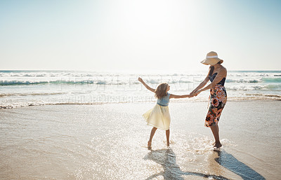 Buy stock photo Shot of a mother and her little daughter bonding together at the beach