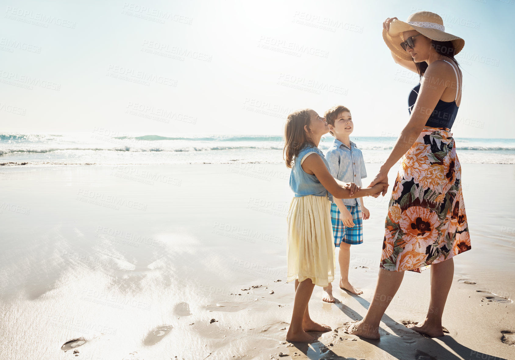 Buy stock photo Shot of a mother bonding with her two little children at the beach