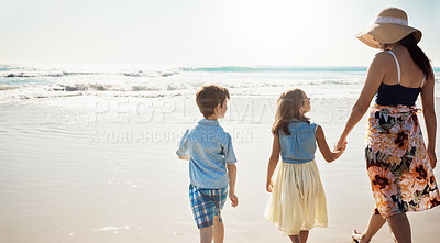 Buy stock photo Rear view shot of a mother bonding with her two little children at the beach