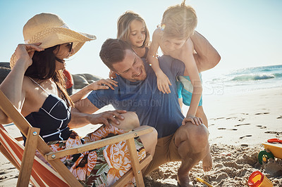 Buy stock photo Shot of a happy family of four having fun at the beach