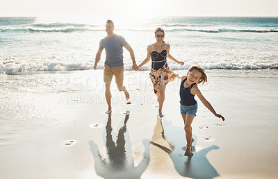 Buy stock photo Shot of a couple at the beach with their young daughter