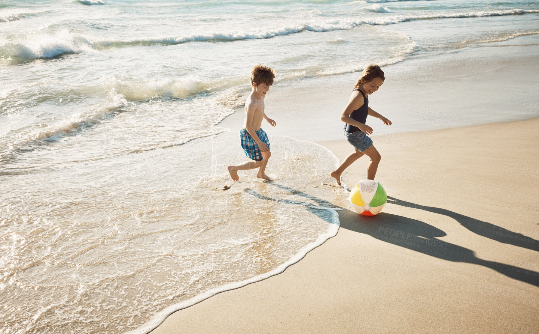 Buy stock photo Shot of a little brother and sister playing together on the beach