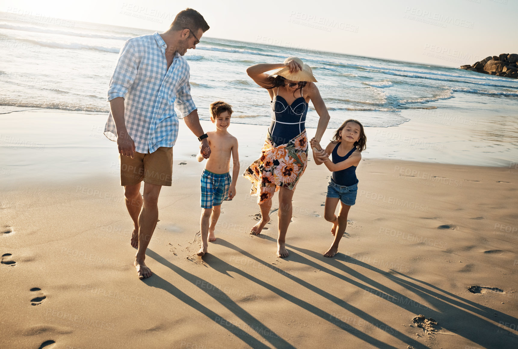 Buy stock photo Happy family, walking and holding hands with kids on beach sunset for summer holiday or bonding together in nature. Mother, father and children with smile for stroll or outdoor weekend by sand shore