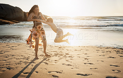 Buy stock photo Shot of a young woman spending the day at the beach with her son