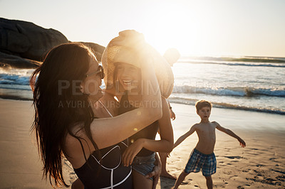 Buy stock photo Shot of a young woman spending the day at the beach with her daughter