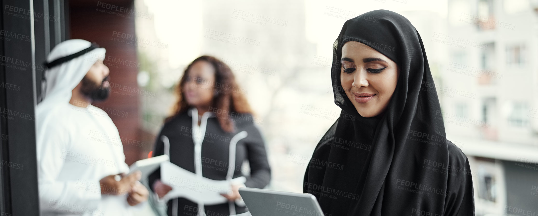 Buy stock photo Cropped shot of an attractive young businesswoman dressed in Islamic traditional clothing using a tablet on her office balcony