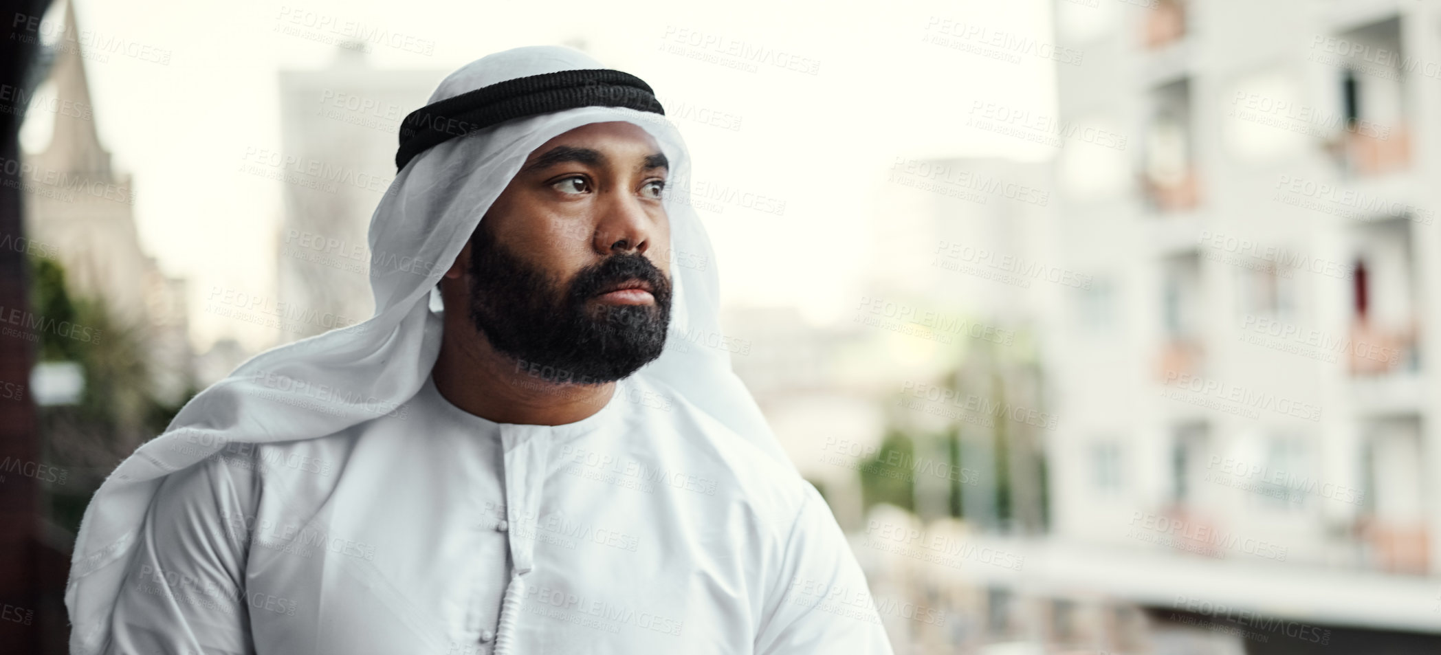 Buy stock photo Cropped shot of a businessman dressed in traditional Islamic clothing working on his office balcony