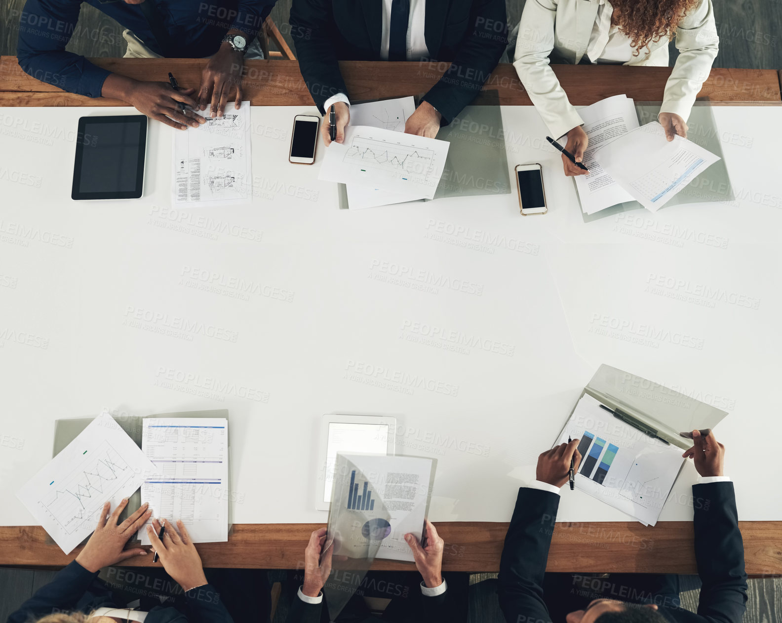 Buy stock photo High angle shot of a team of businesspeople working around a table in the office