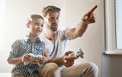 Buy stock photo Cropped shot of a young boy and his father playing video games