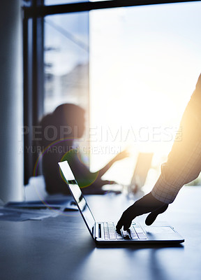 Buy stock photo Silhouette of the hand of a businessman working on a laptop in an office with sunlight and a blurred shadow of a woman in the background with bokeh. Outline of a male brainstorming in the office.
