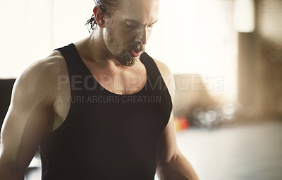 Buy stock photo Cropped shot of a handsome young man working out in the gym