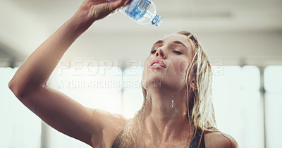 Buy stock photo Cropped shot of an attractive young woman pouring water on her face during a workout in the gym