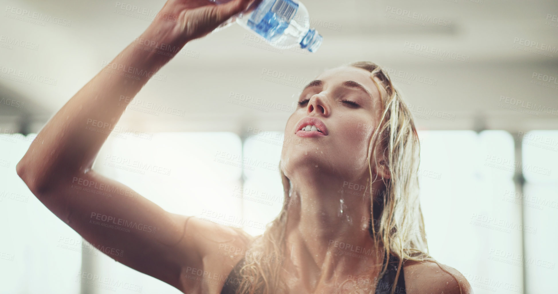 Buy stock photo Cropped shot of an attractive young woman pouring water on her face during a workout in the gym