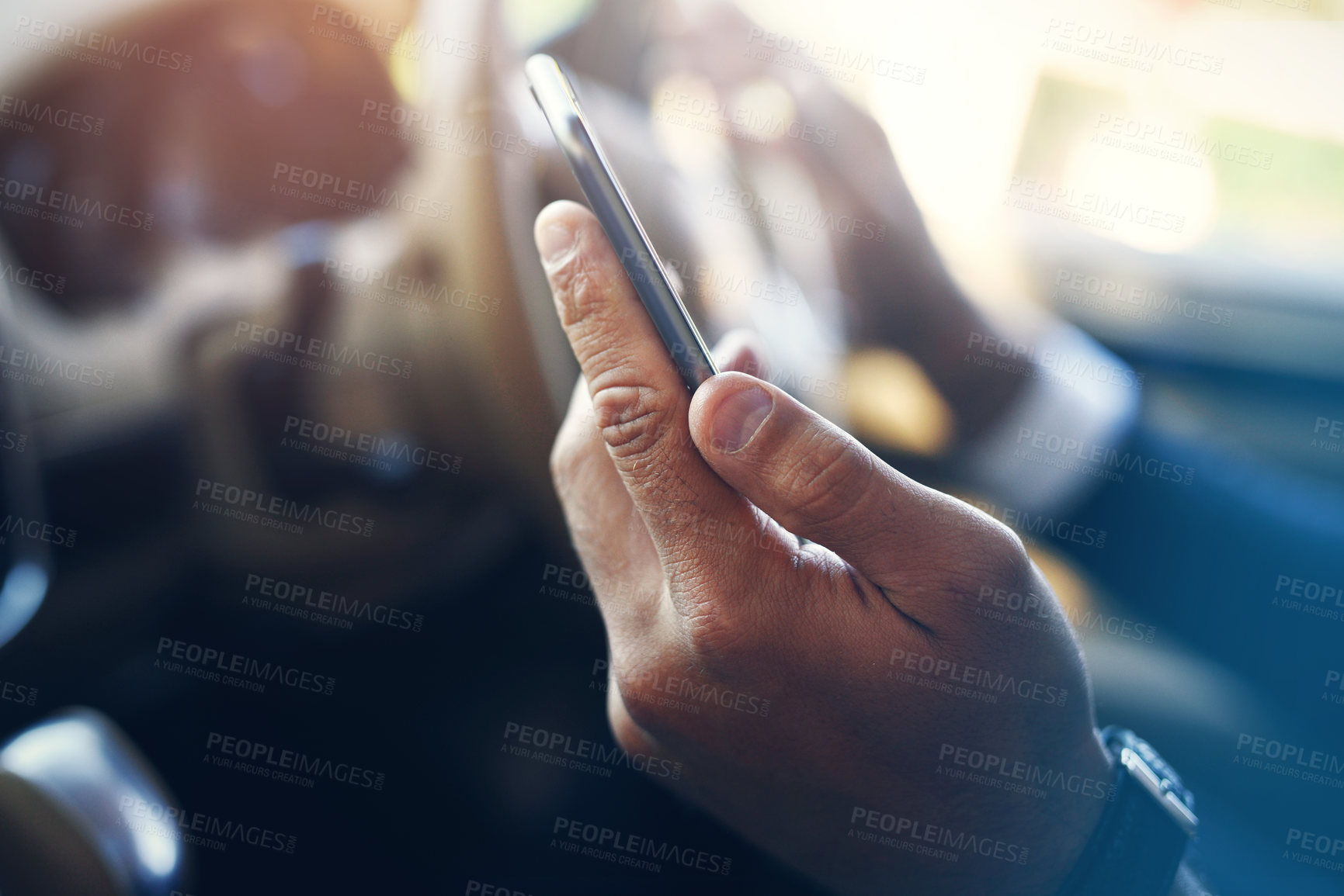 Buy stock photo Shot of an unrecognizable person's hand holding a cellphone inside of a car during the day