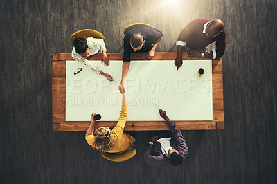 Buy stock photo High angle shot of businesspeople shaking hands during a meeting with colleagues