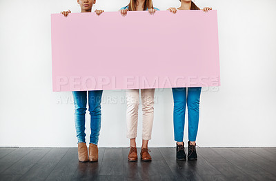 Buy stock photo Cropped studio shot of a group of young women holding a blank placard against a white background