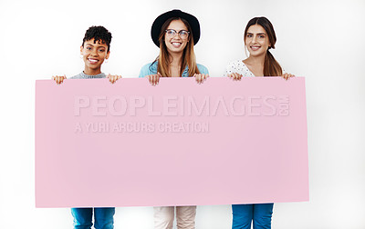 Buy stock photo Studio shot of a group of young women holding a blank placard against a white background