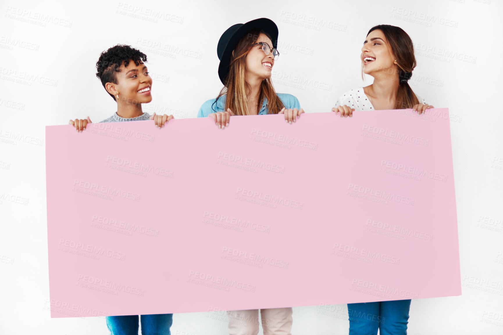 Buy stock photo Studio shot of a group of young women holding a blank placard against a white background