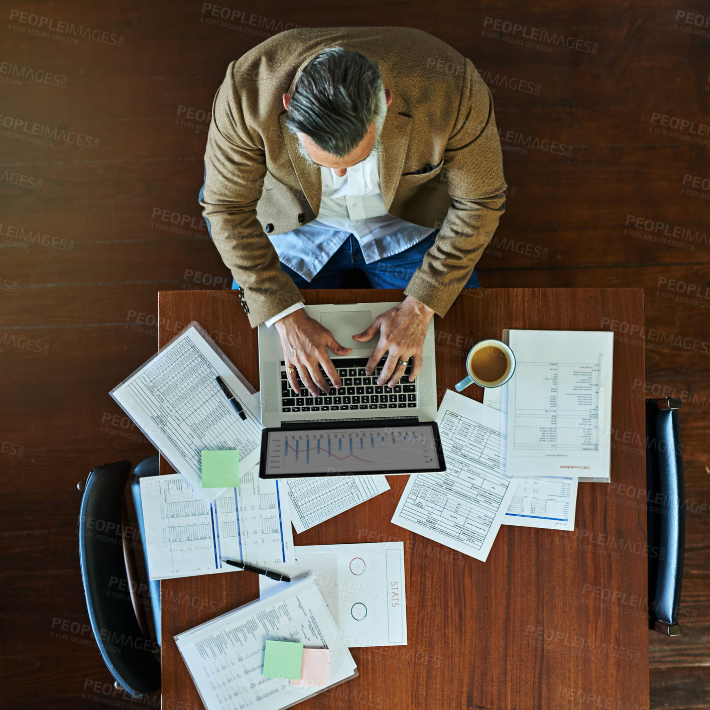 Buy stock photo Mature businessman, laptop and above with documents, typing and reading charts on screen for finance. Person, computer and paperwork for accounting, graphs and stats with review at office in Italy