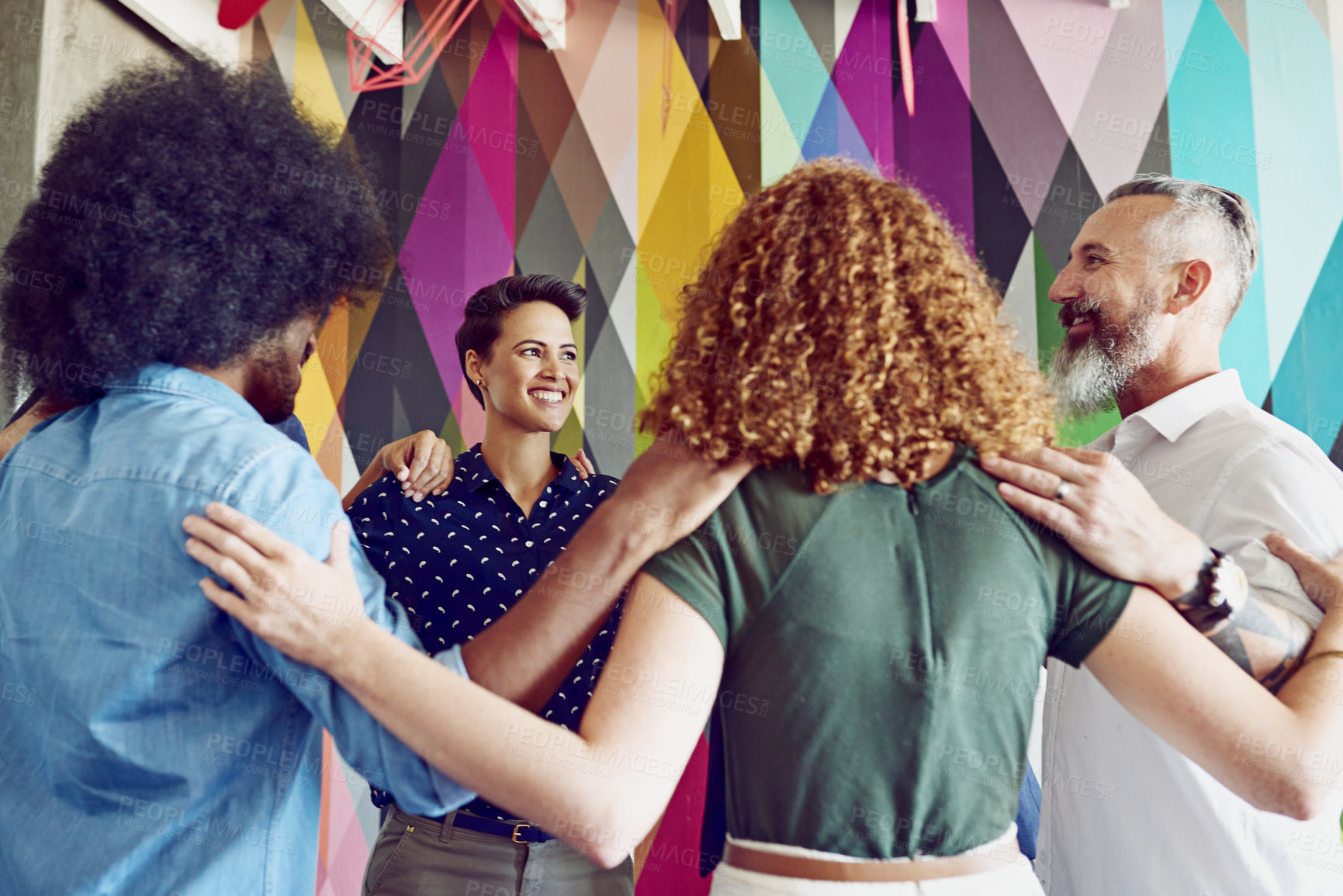 Buy stock photo Shot of a group of designers standing in a huddle in an office