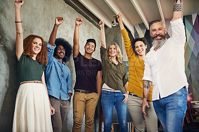 Buy stock photo Portrait of a group of designers raising their fists in an office
