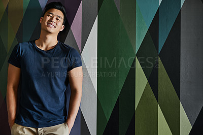 Buy stock photo Portrait of a cheerful young man standing with his hands in his pockets against a multi colored background