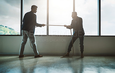 Buy stock photo Shot of two young businessmen pulling on a rope in a game of tug of war