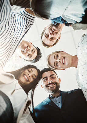 Buy stock photo Low angle shot of a group of cheerful businesspeople standing in a circle while looking down at the camera in the office