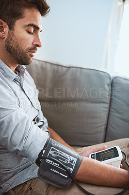 Buy stock photo Hypertension, stress and man test blood pressure in a home sofa or living room for medical or health exam. Monitor, reading and man with equipment or machine for chronic disease in a house