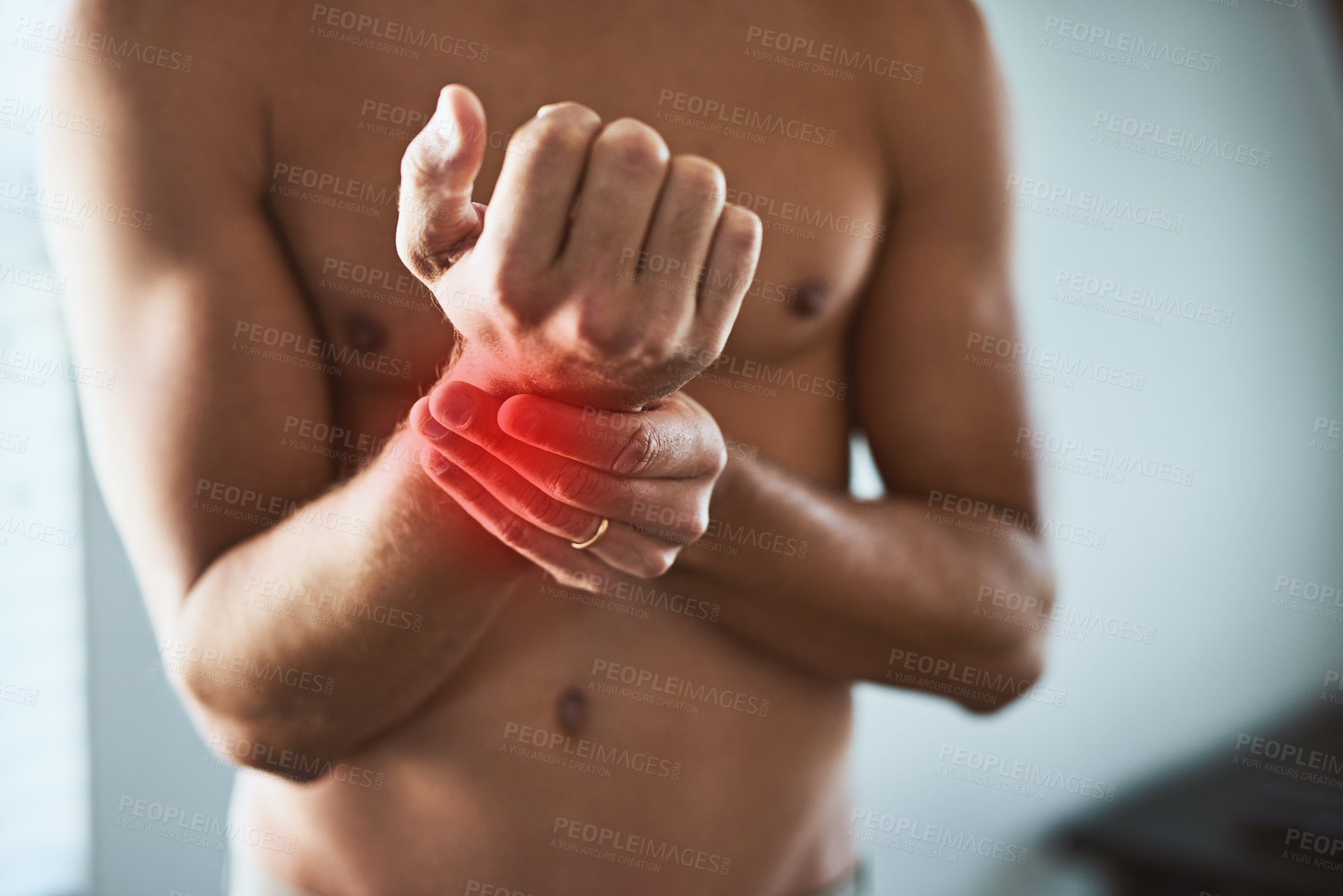 Buy stock photo Man, pain and touch wrist for injury, medical problem and joint inflammation for arthritis disease in home. Topless guy, holding hand and massage with red glow, carpal tunnel and fibromyalgia