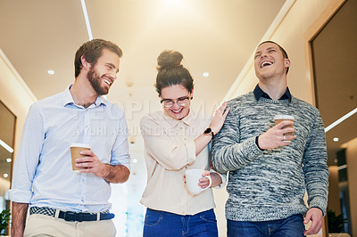 Buy stock photo Shot of a group of young businesspeople walking together down a passage while drinking coffee