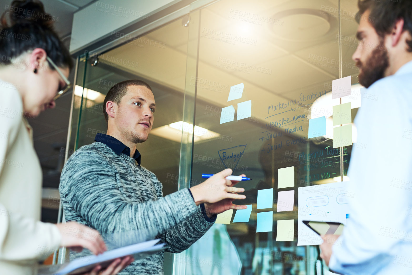 Buy stock photo Talking, coworkers and glass wall for brainstorming ideas in startup for collaboration and teamwork. Group, staff or people in meeting discussion for solution, planning or project in creative agency