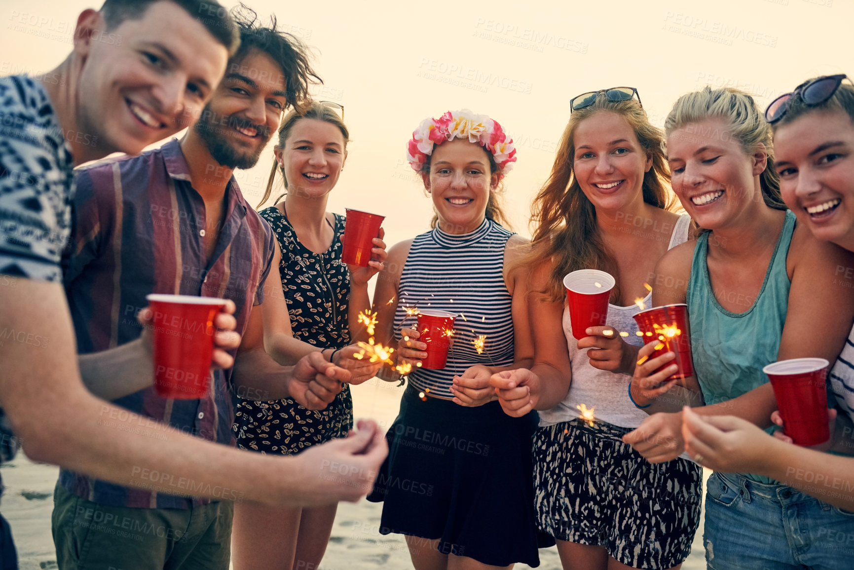 Buy stock photo Group, sparklers and beach with friends portrait at sunset party for summer, vacation or holiday in nature together. New years, drinks and celebration with people, bonding and drinking by Miami sea