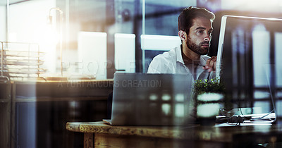 Buy stock photo Cropped shot of a handsome young businessman working late in the office