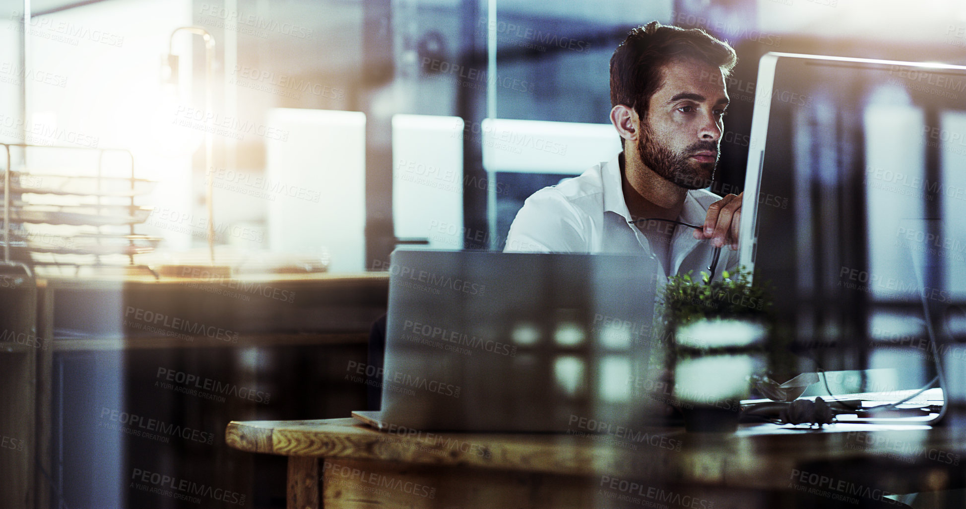 Buy stock photo Cropped shot of a handsome young businessman working late in the office