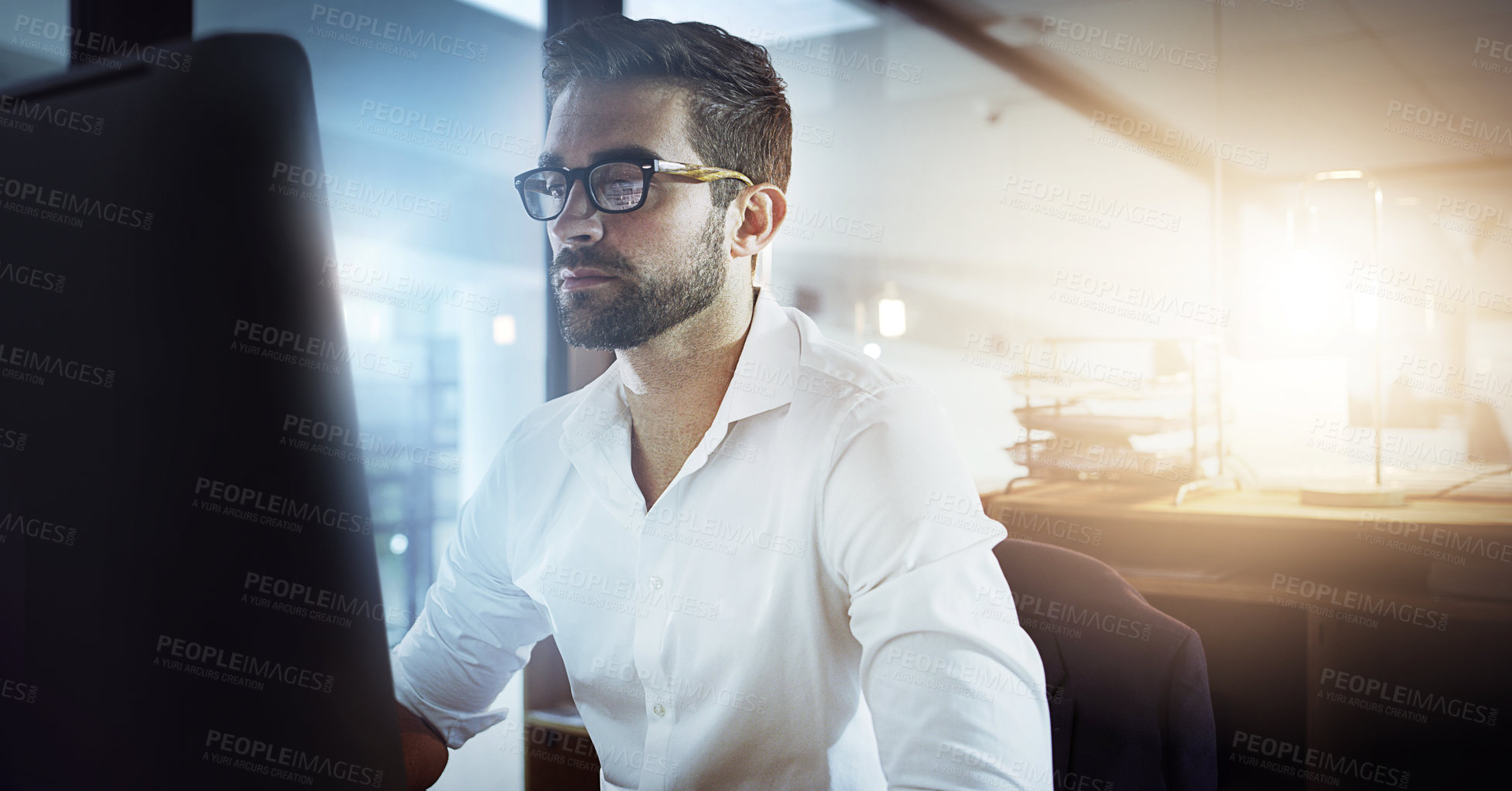 Buy stock photo Cropped shot of a handsome young businessman working late in the office