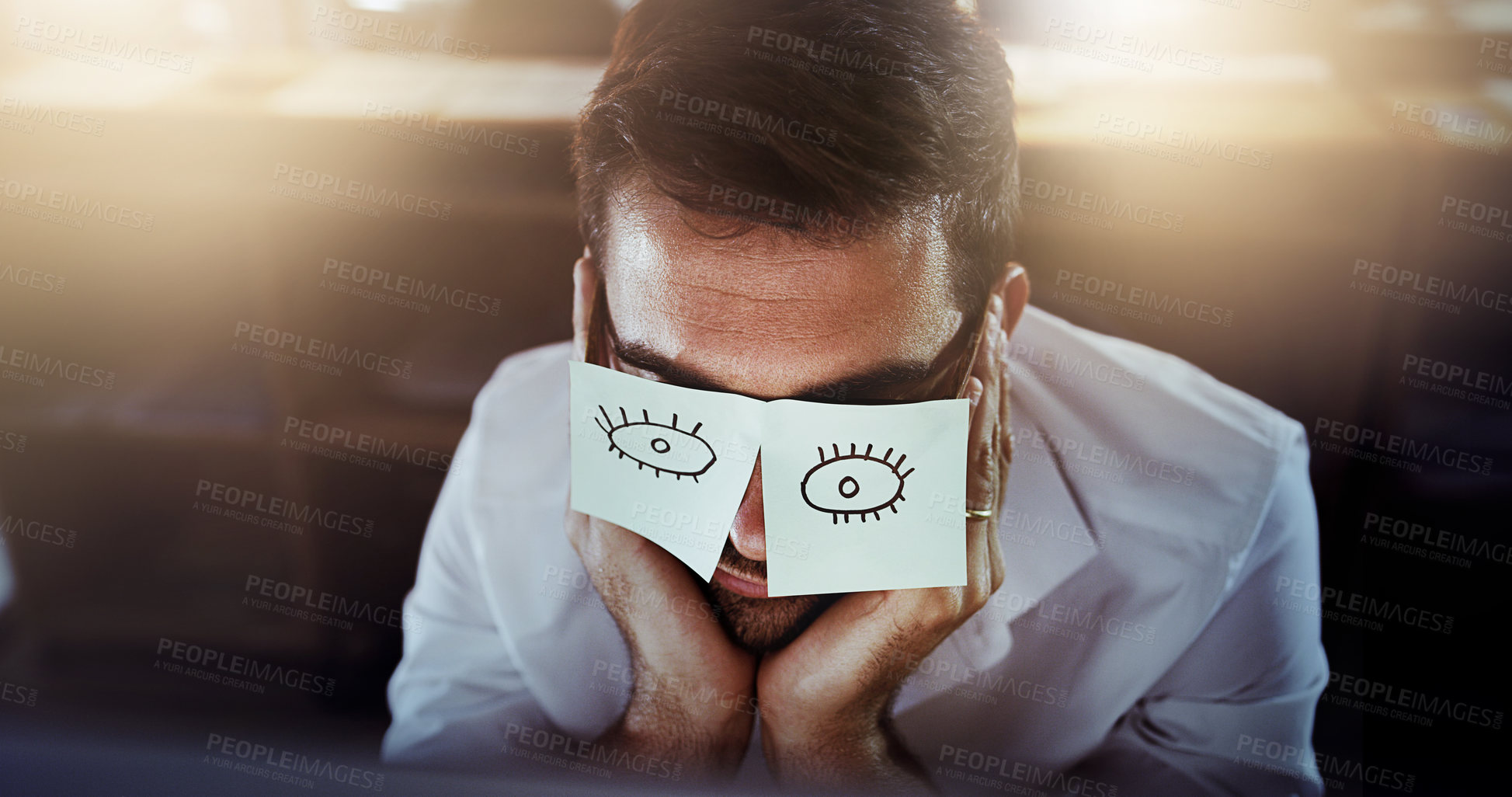 Buy stock photo Cropped shot of a young man with sticky notes over his glasses working late in his office