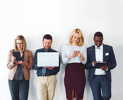 Buy stock photo Shot of a group of entrepreneurs using wireless devices against a white background