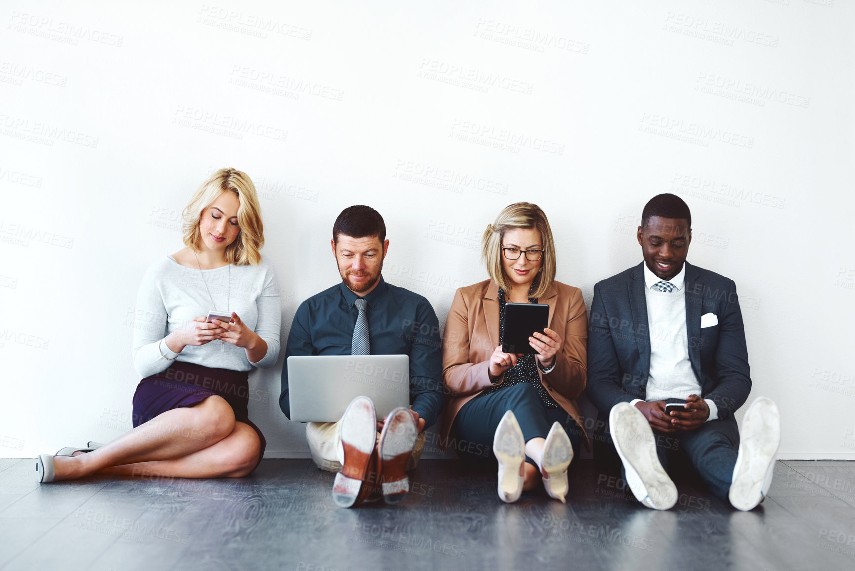 Buy stock photo Shot of a group of entrepreneurs using wireless devices against a white background